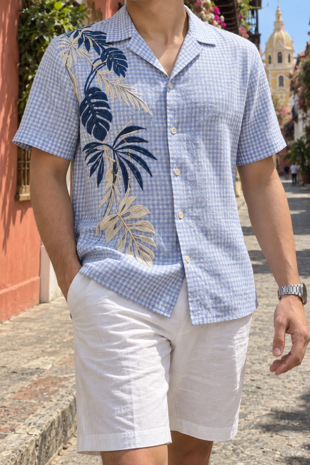 Detalle de las hojas de palma bordadas en azul marino y beige sobre la camisa de cuadros azul claro.