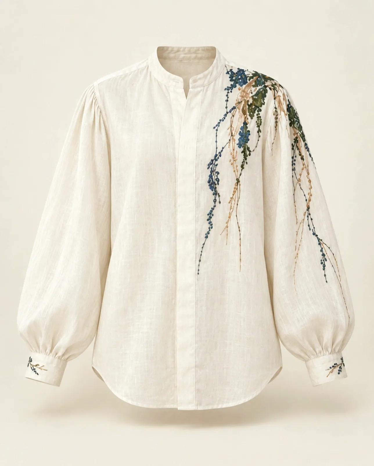 Camisa marfil terminada, con el bordado de ramas en verde, cobalto y cobre.